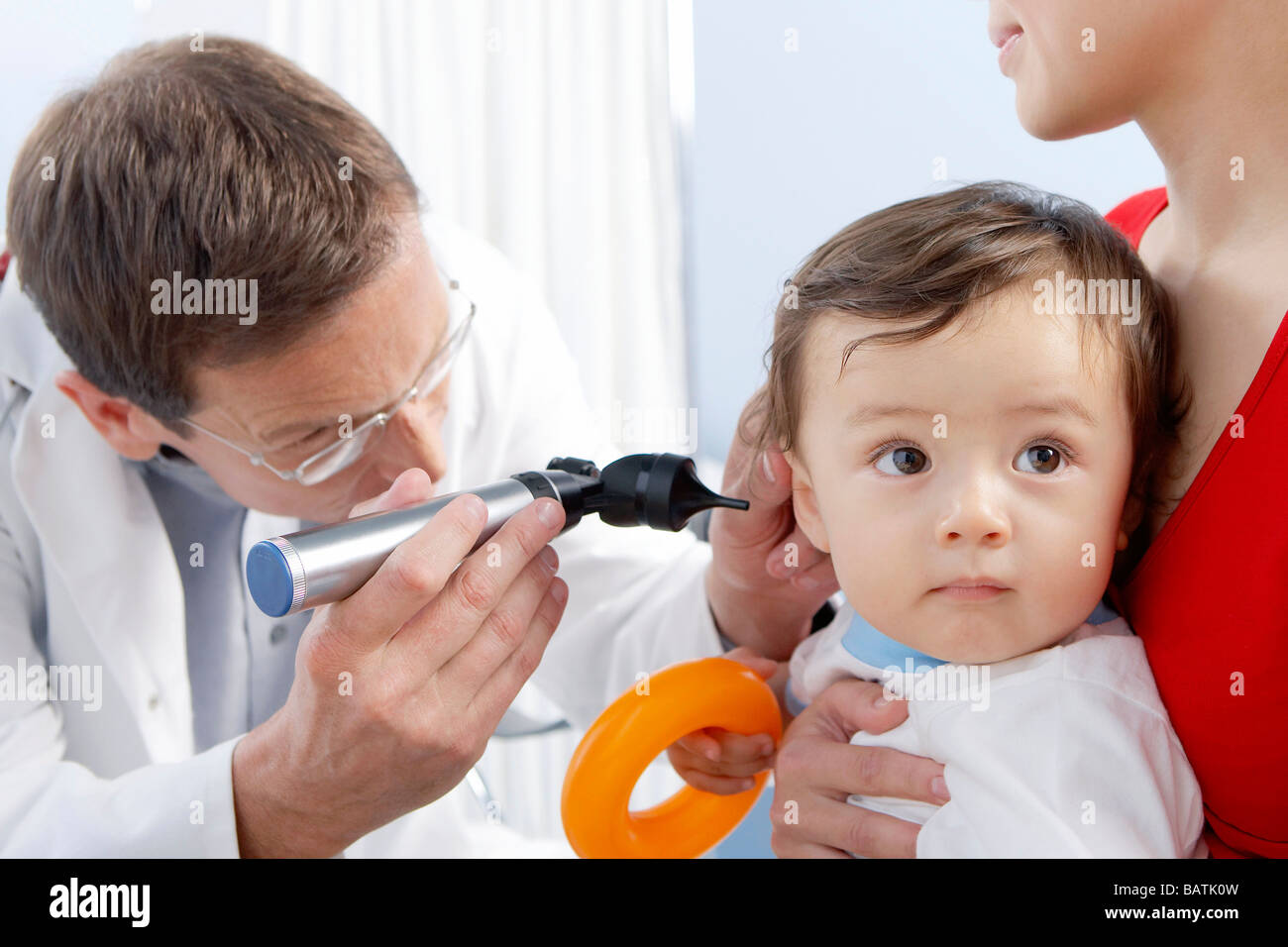 Ear examination. Otoscope being used by a general practice doctor to