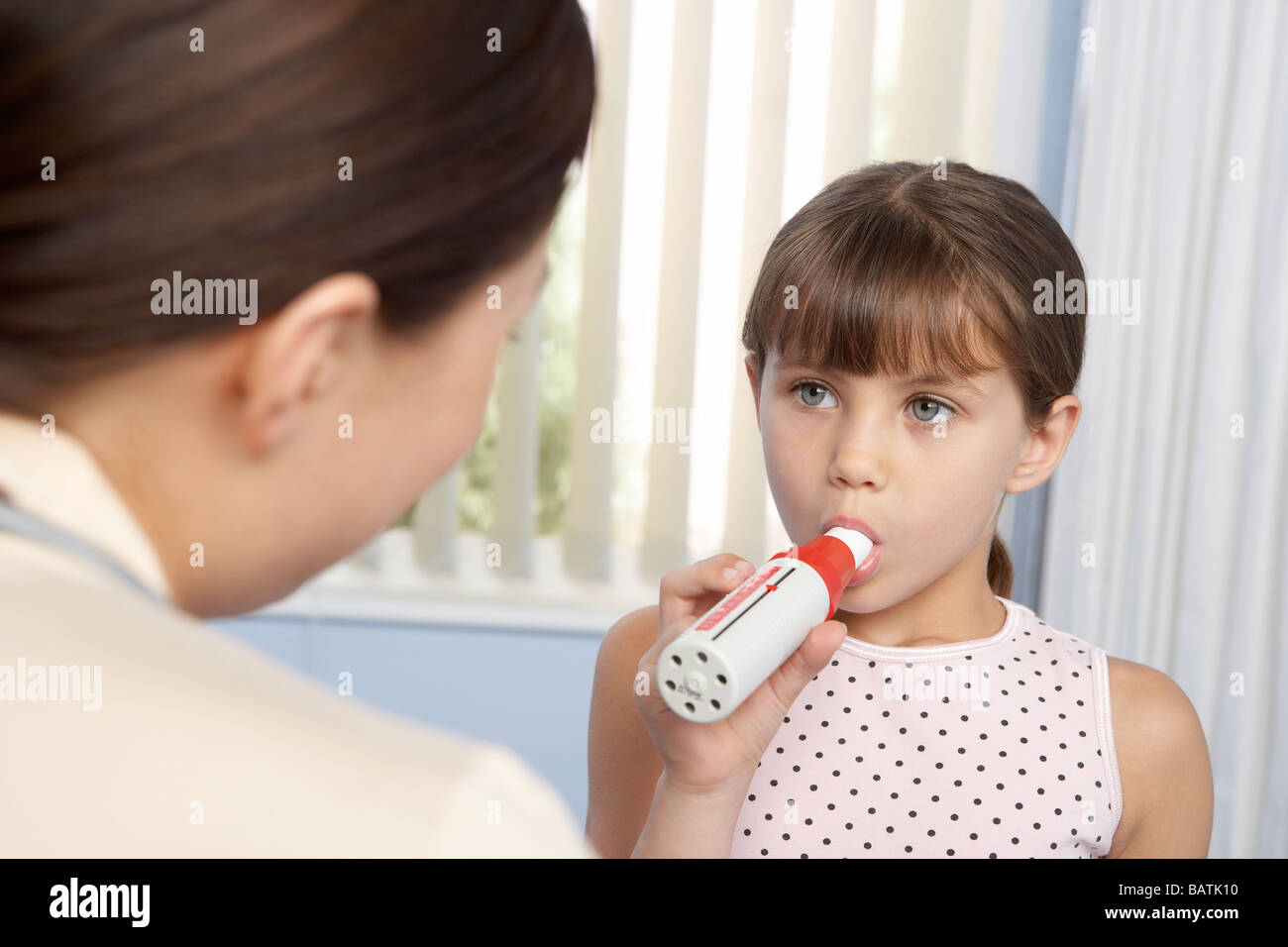 Lung fucntion test. Six year old girl breathing into a peak flow meter