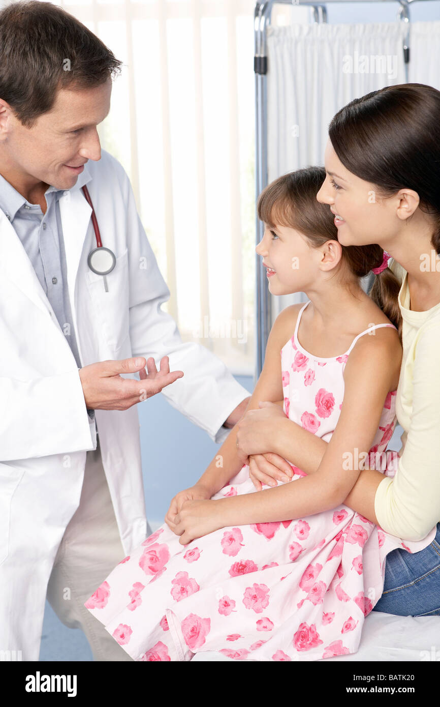 Doctor and child. Mother holding her daughter as she talks to a doctor