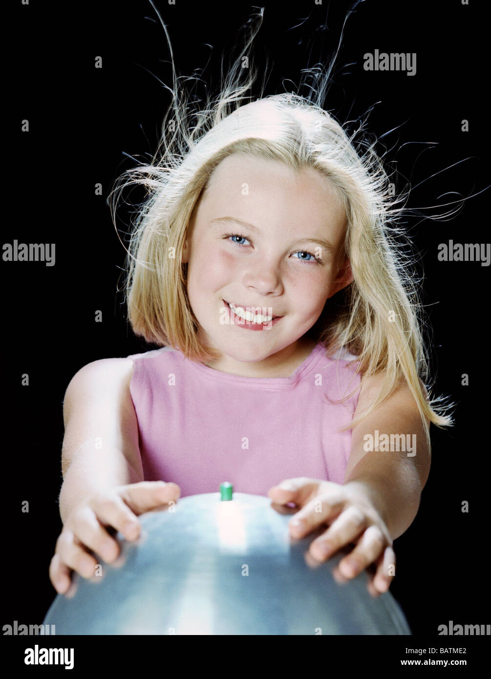 Van de Graaff generator. Seven year old girl using a van de Graaff
