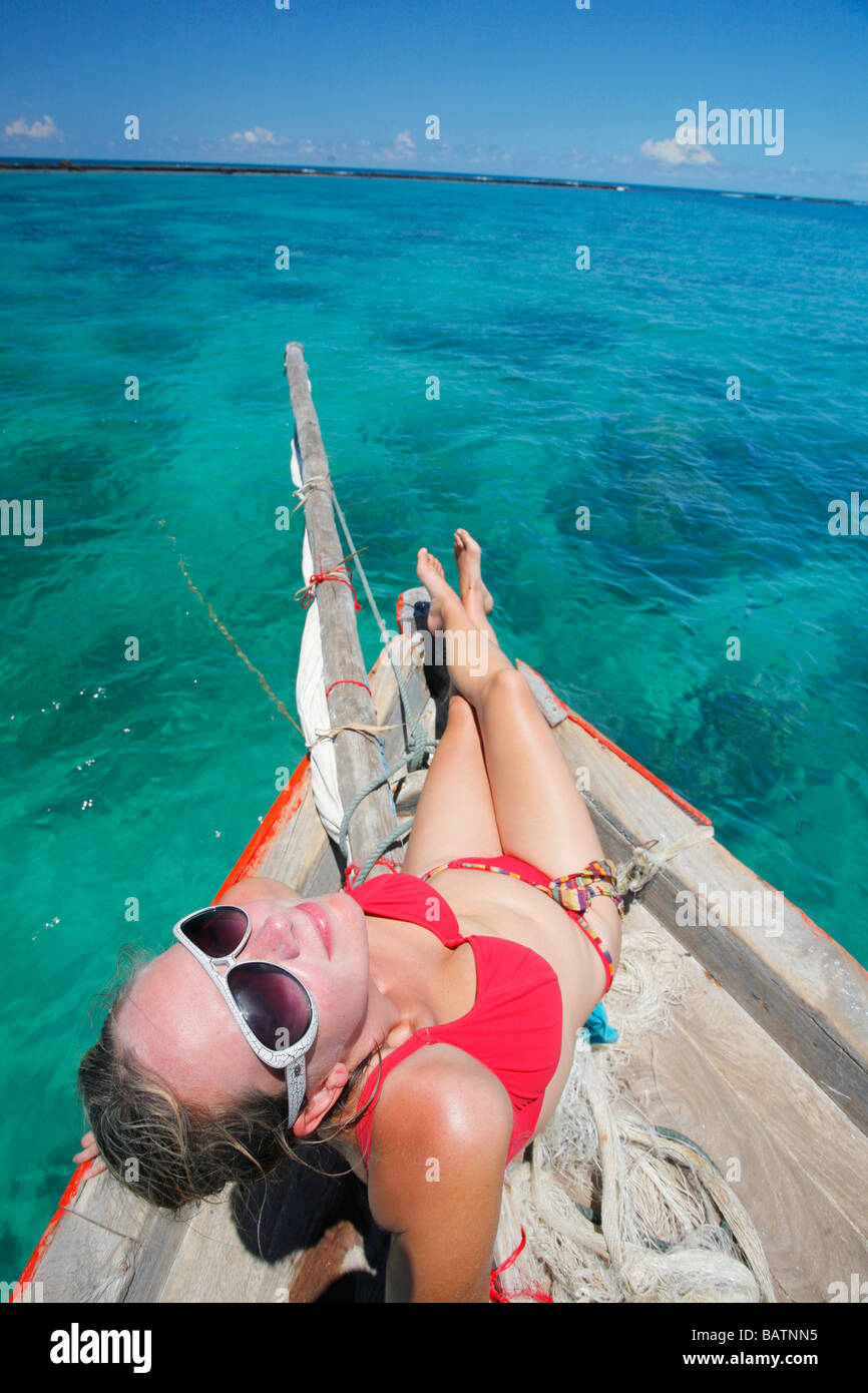 Sunbathing on the front of a Dhow sailing to the Bazaruto Archipelago from Vilanculos in Mozambique Stock Photo