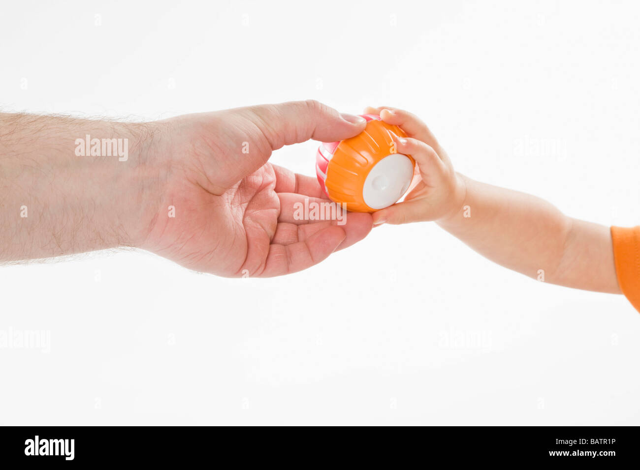 man giving ball to a baby, close-up view Stock Photo