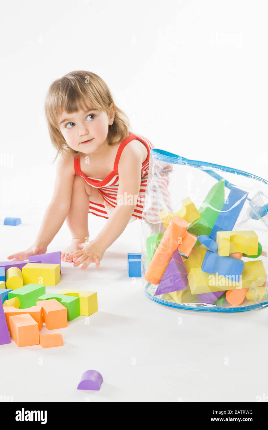 baby girl tidy up blocks into bag Stock Photo Alamy