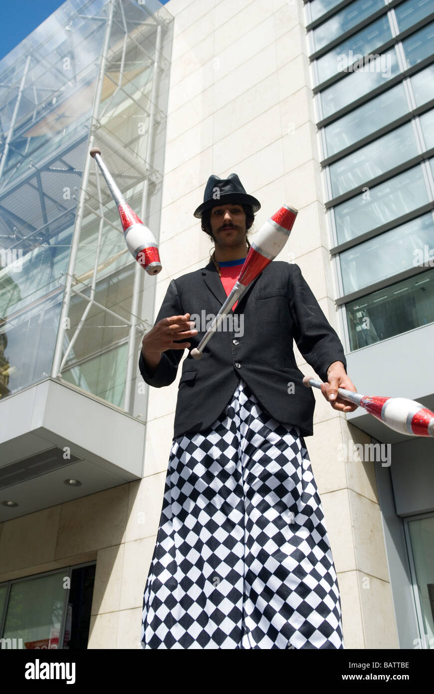 Stilt walker juggling in the Spanish festival in Manchester UK Stock