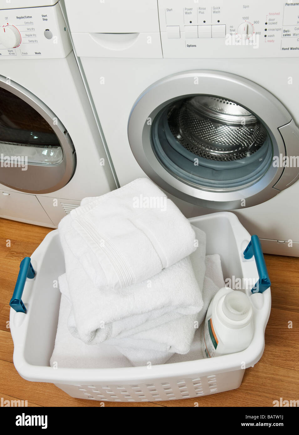 Laundry in basket in launderette Stock Photo Alamy