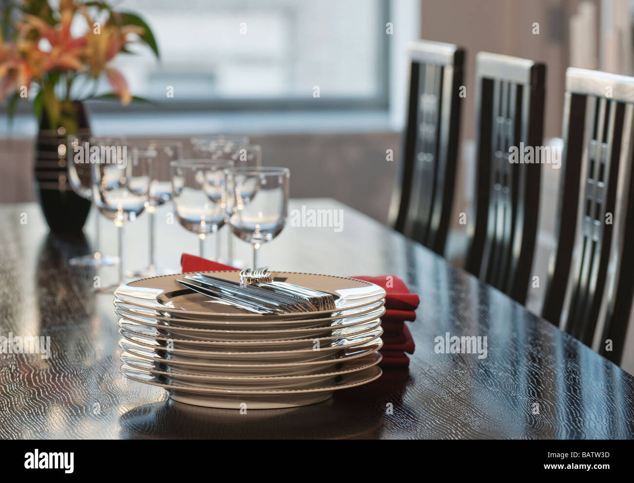 Stack of plates on table in dining room Stock Photo
