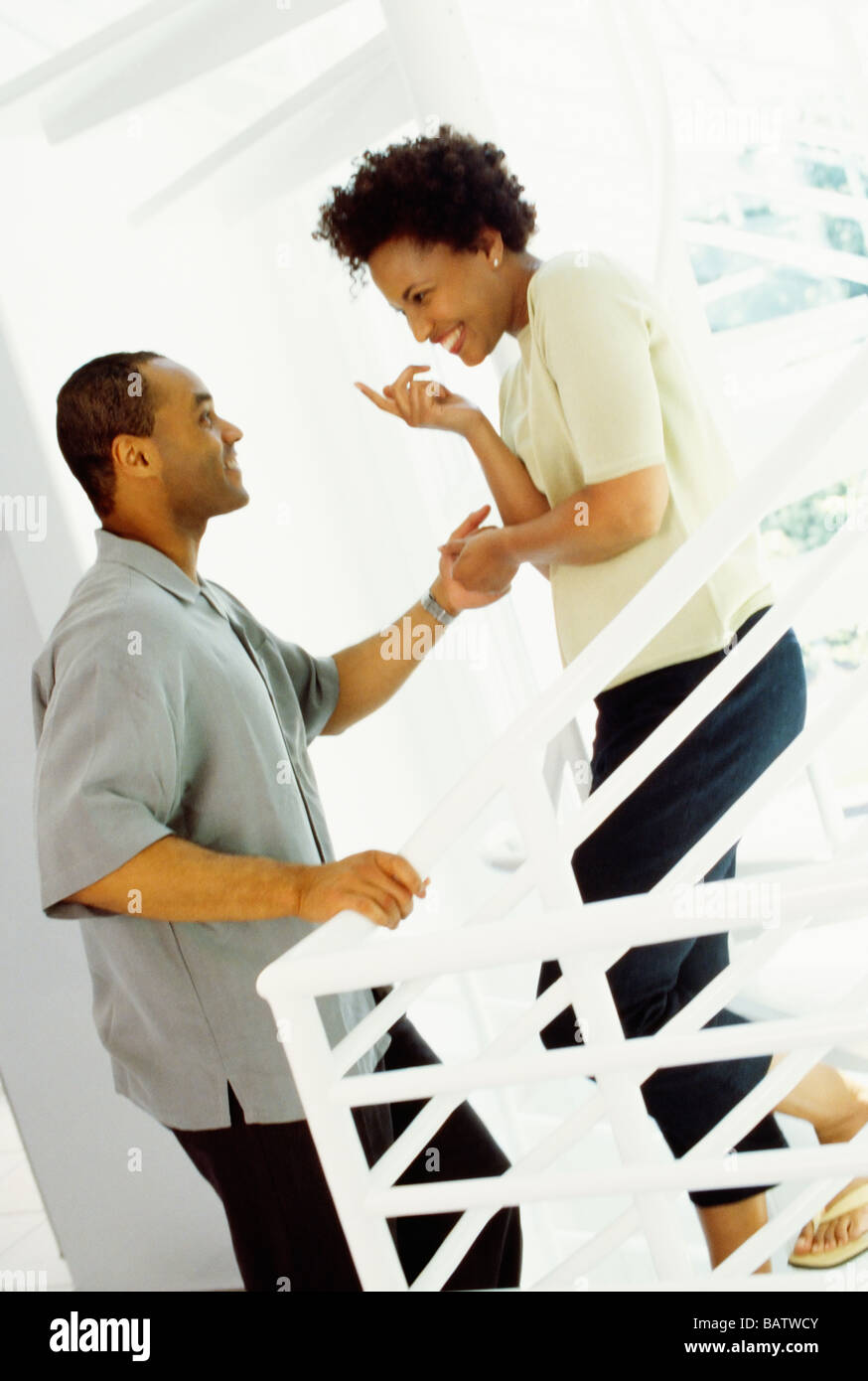 African woman tempting husband upstairs Stock Photo