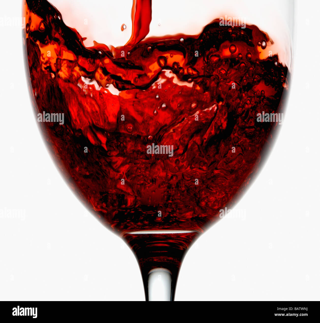 Red wine being poured into wineglass, close-up Stock Photo