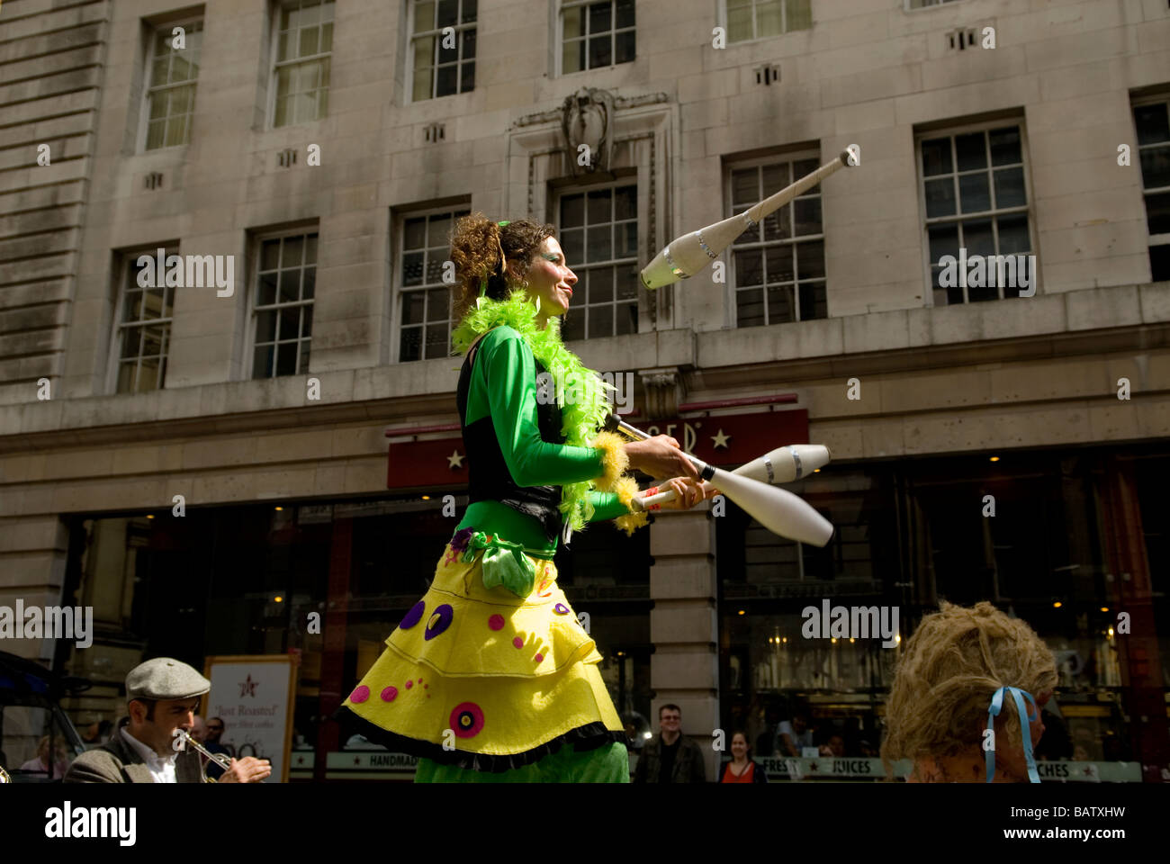 Stilt walker juggling in The Spanish festival parade in Manchester UK
