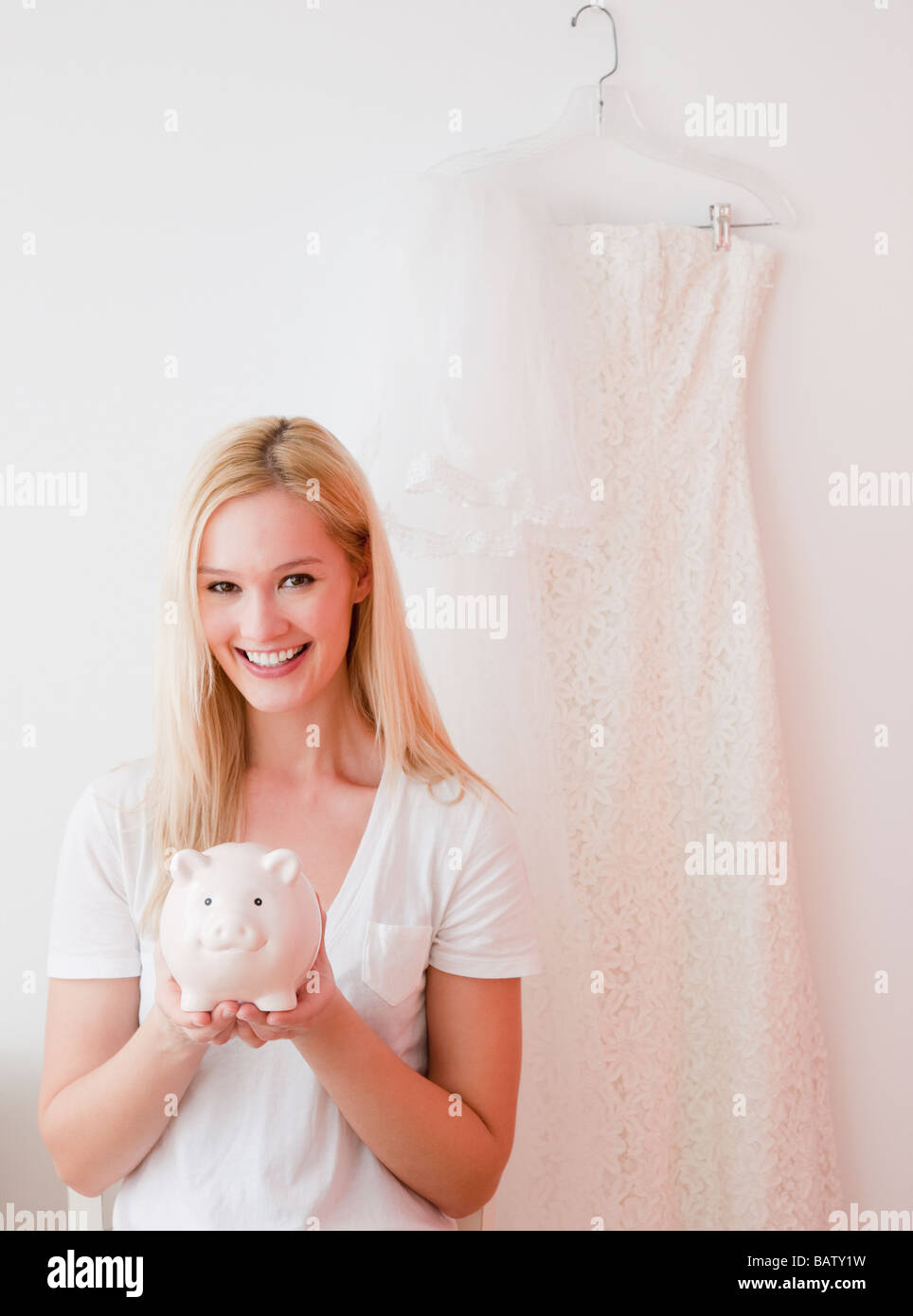 Portrait of young woman holding piggy bank with savings for wedding Stock Photo