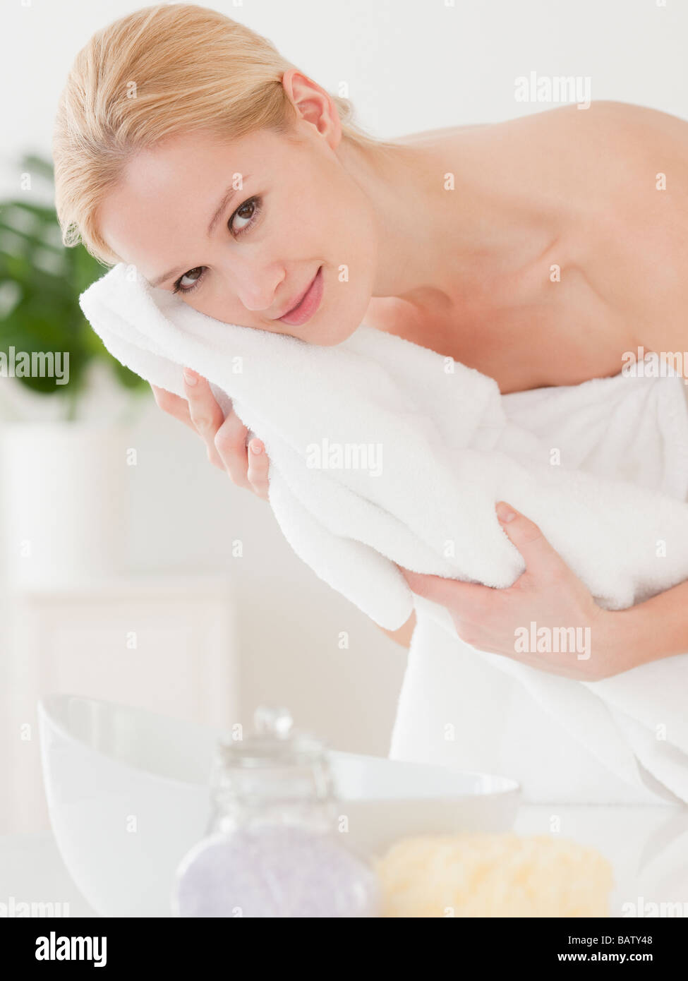 Young woman wrapped in towel and drying face, portrait Stock Photo - Alamy