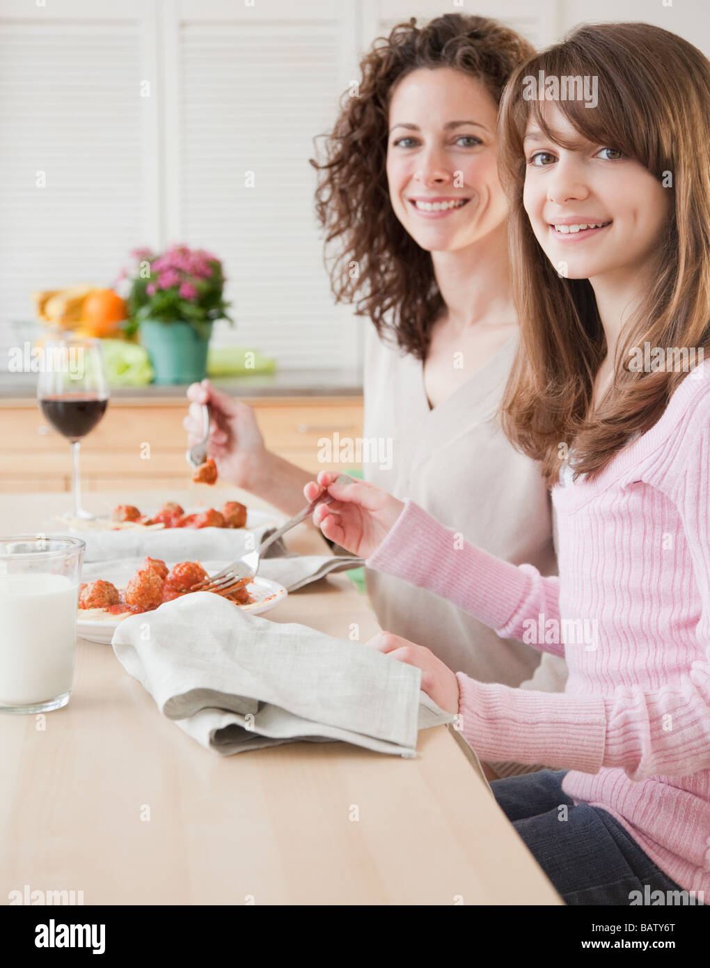 Mother and daughter (10-11 years) eating dinner, portrait Stock Photo
