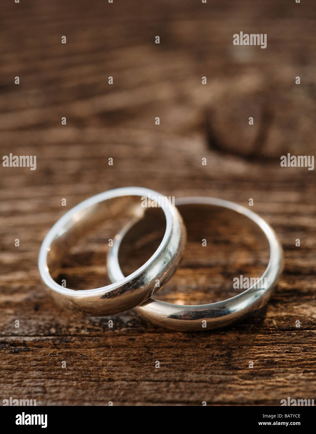 Two wedding rings on wooden table Stock Photo - Alamy