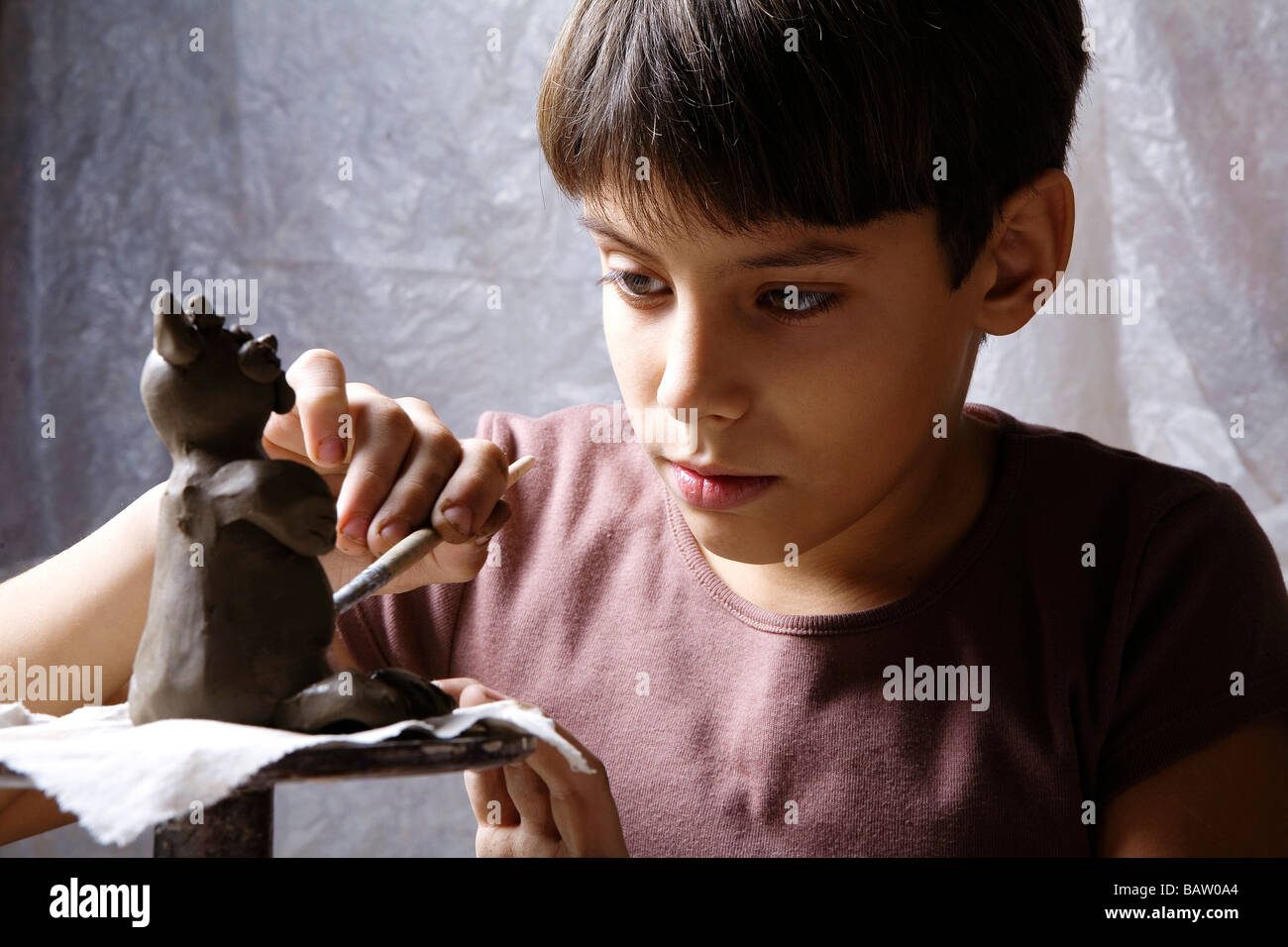 young boy forming little sculpture out of clay Stock Photo Alamy