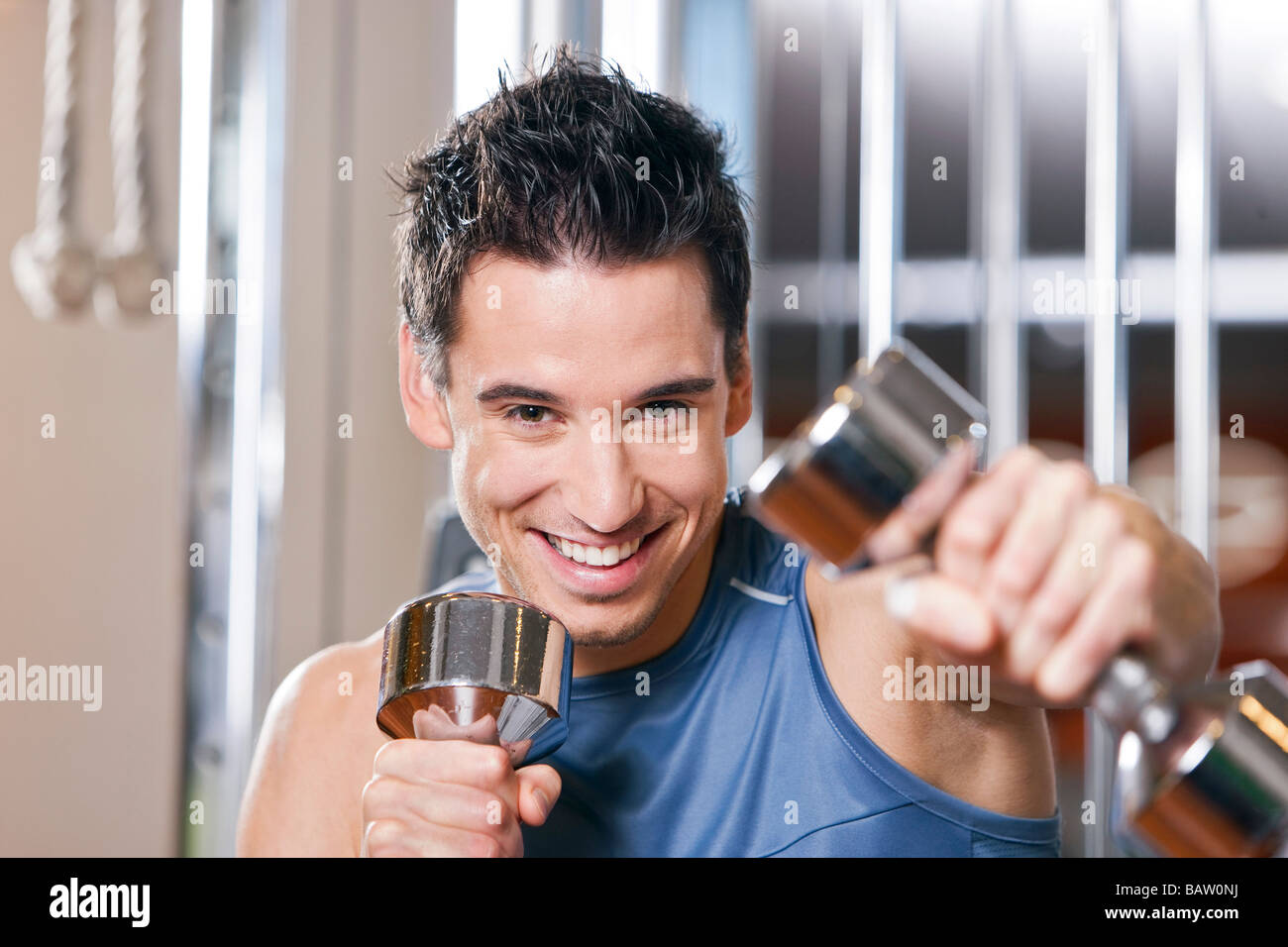 portrait of young man exercising with dumb bells Stock Photo