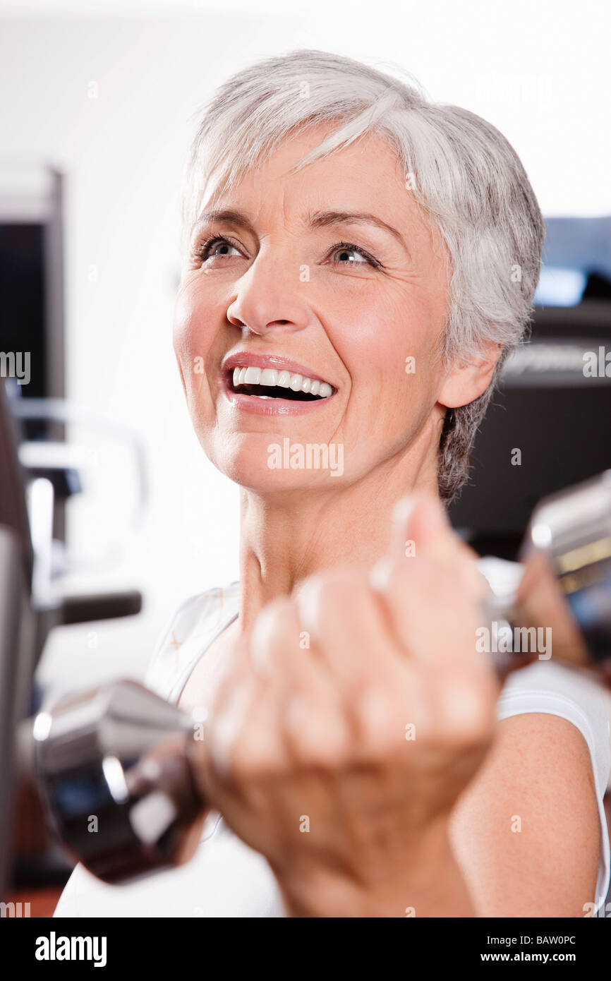 portrait of mature woman exercising with dumb bells Stock Photo