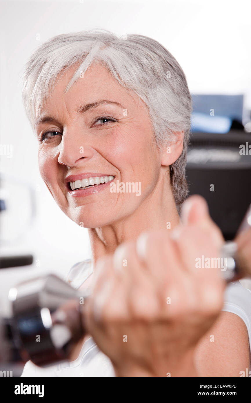 portrait of mature woman exercising with dumb bells Stock Photo