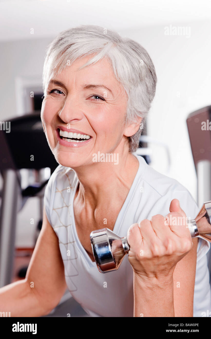 portrait of mature woman exercising with dumb bells Stock Photo