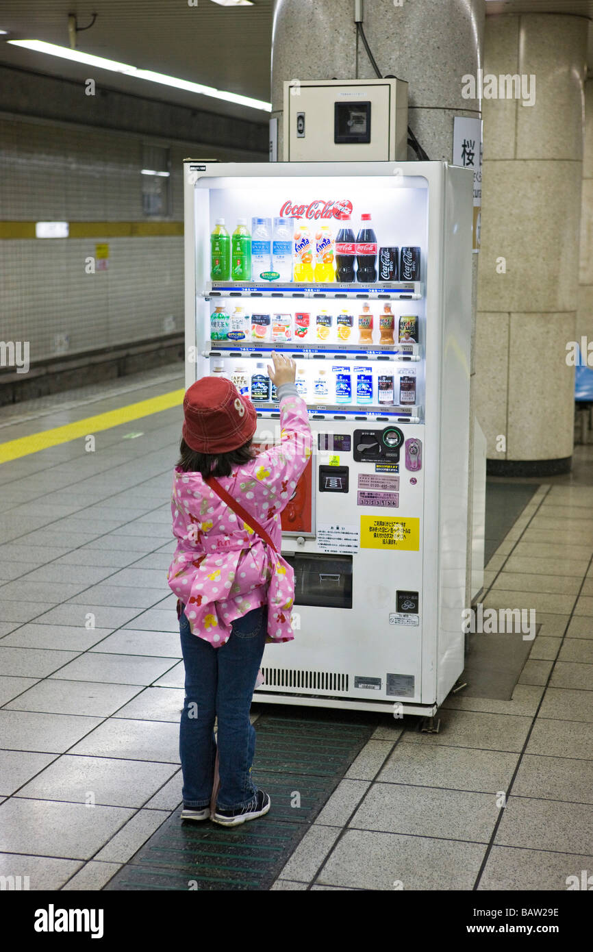 young girl using vending machine at subway station Stock Photo