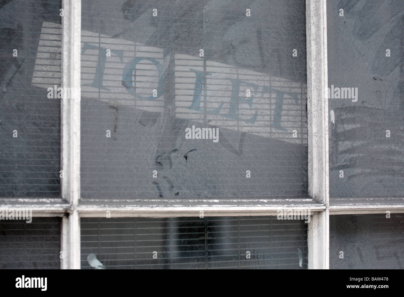 'To Let' sign displayed in disused and empty shop window. Stock Photo