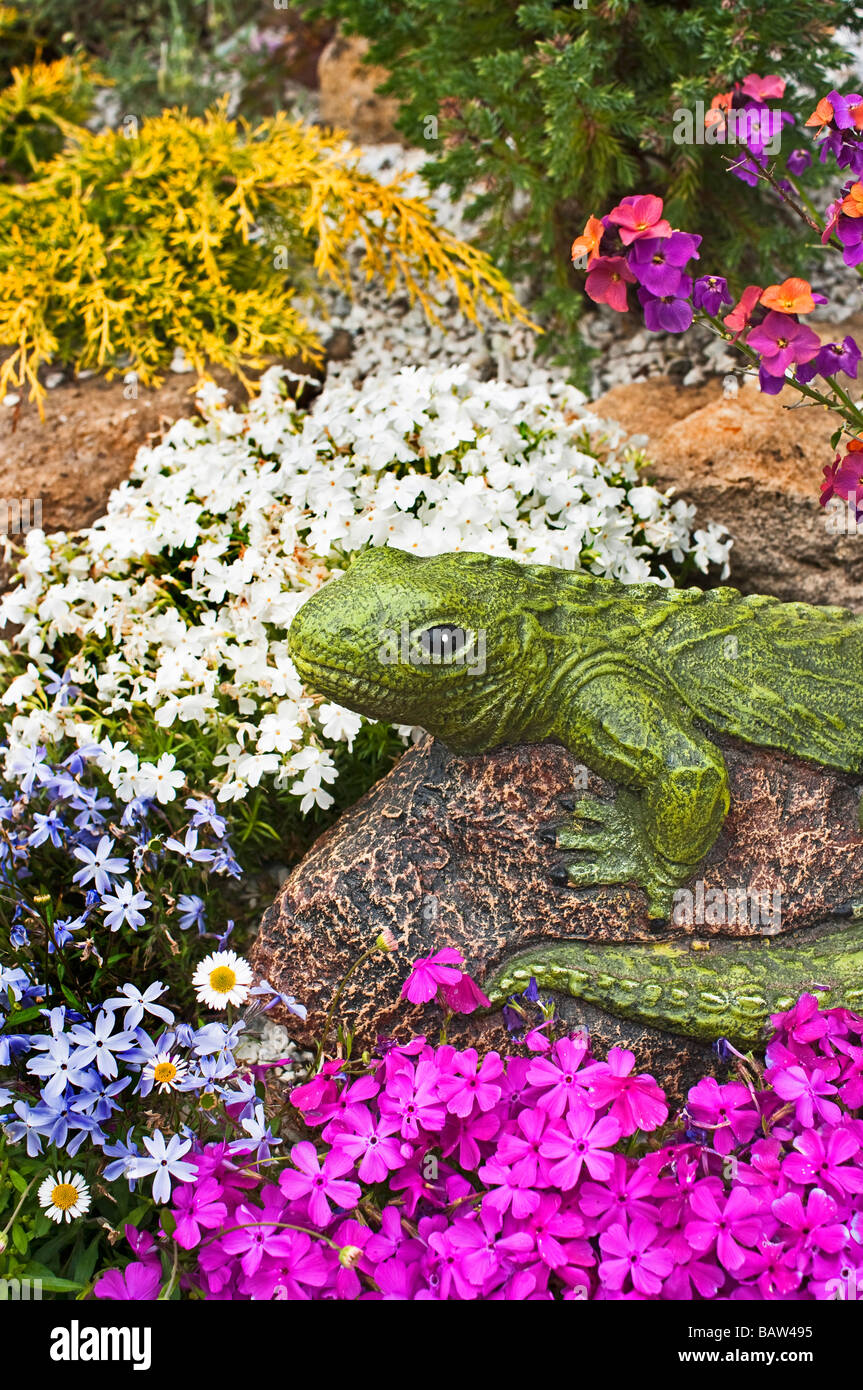 Small rockery garden with phlox and model reptile Stock Photo - Alamy
