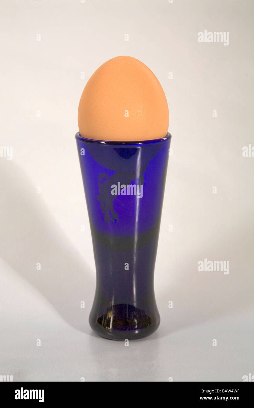 A soft boiled egg in an egg cup with salt and pepper shakers Stock