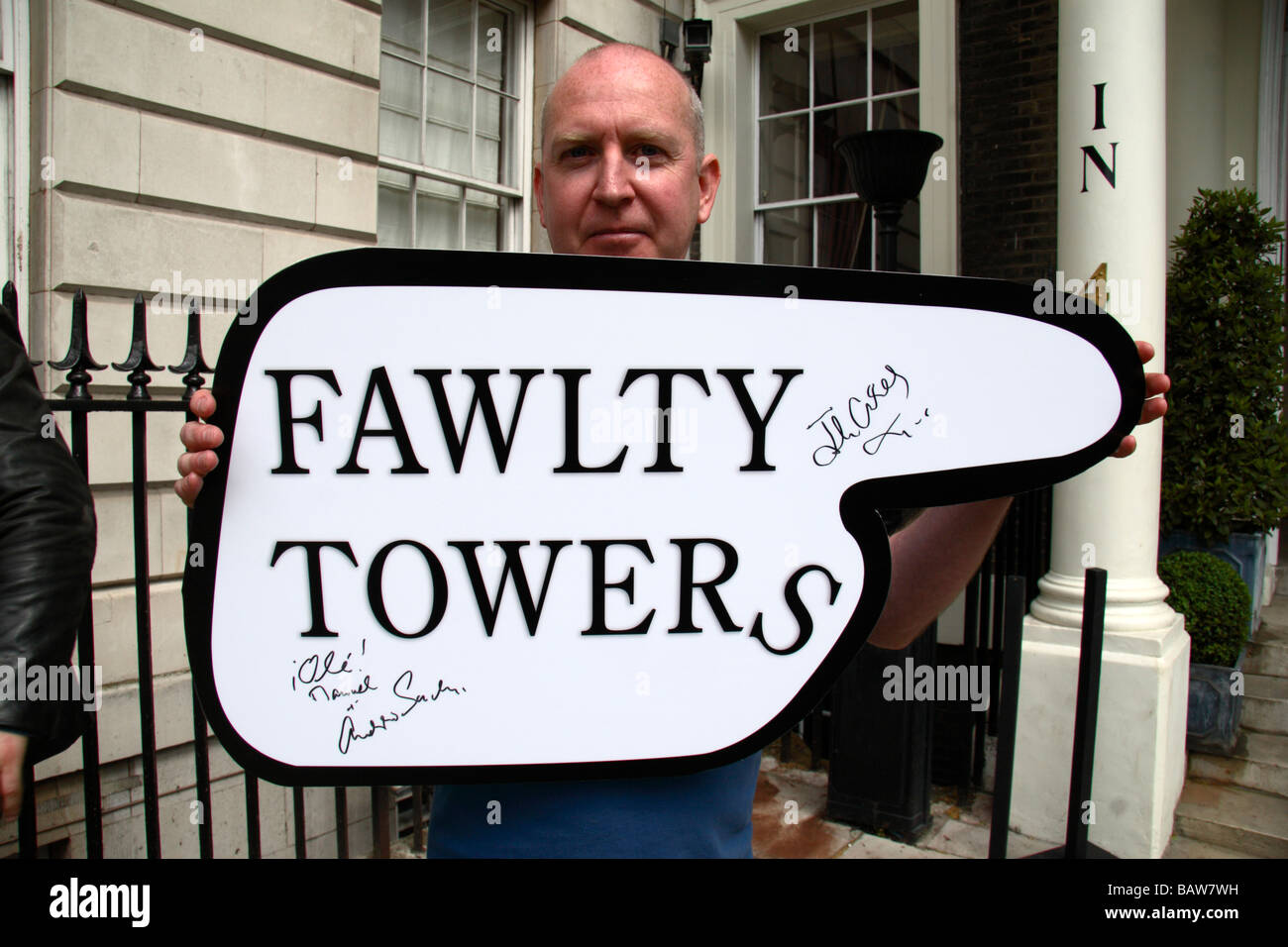 A fan holds a 'Fawlty Towers' sign autographed by Andrew Sachs and John Cleese at the launch of a new Fawlty Towers programme. Stock Photo