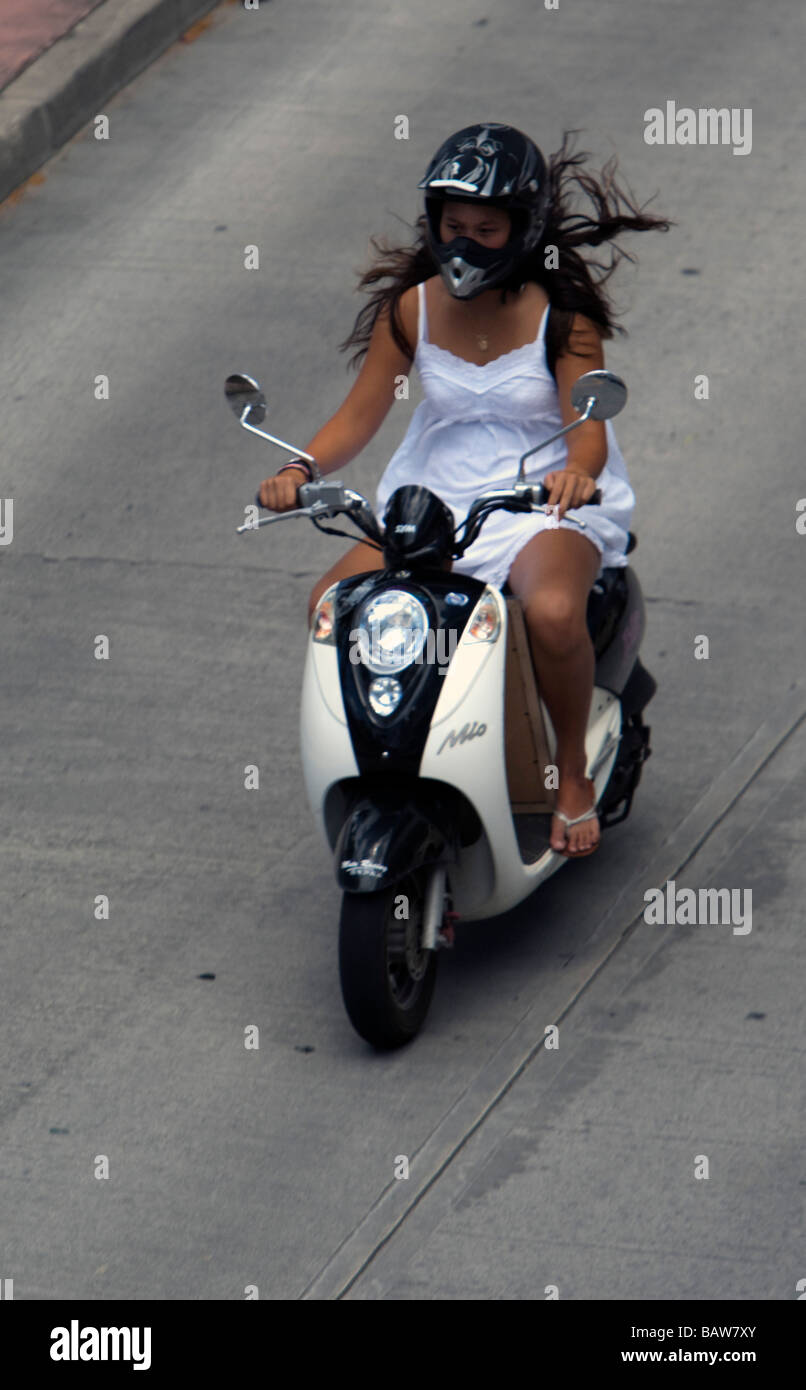 Young woman rides motor scooter St Barts Stock Photo