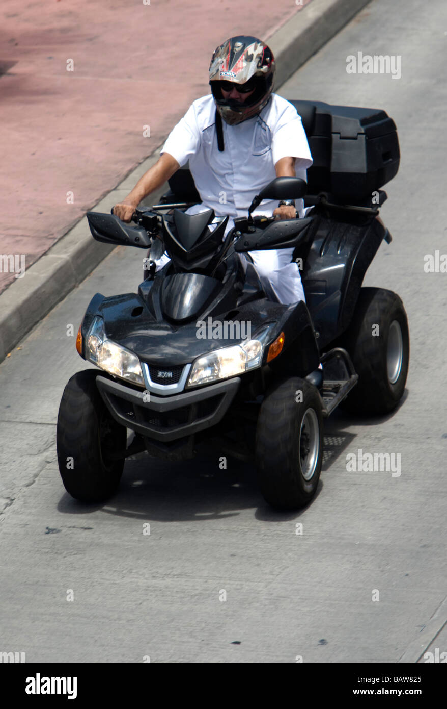 Young man rides ATV personal transport St Barts Stock Photo