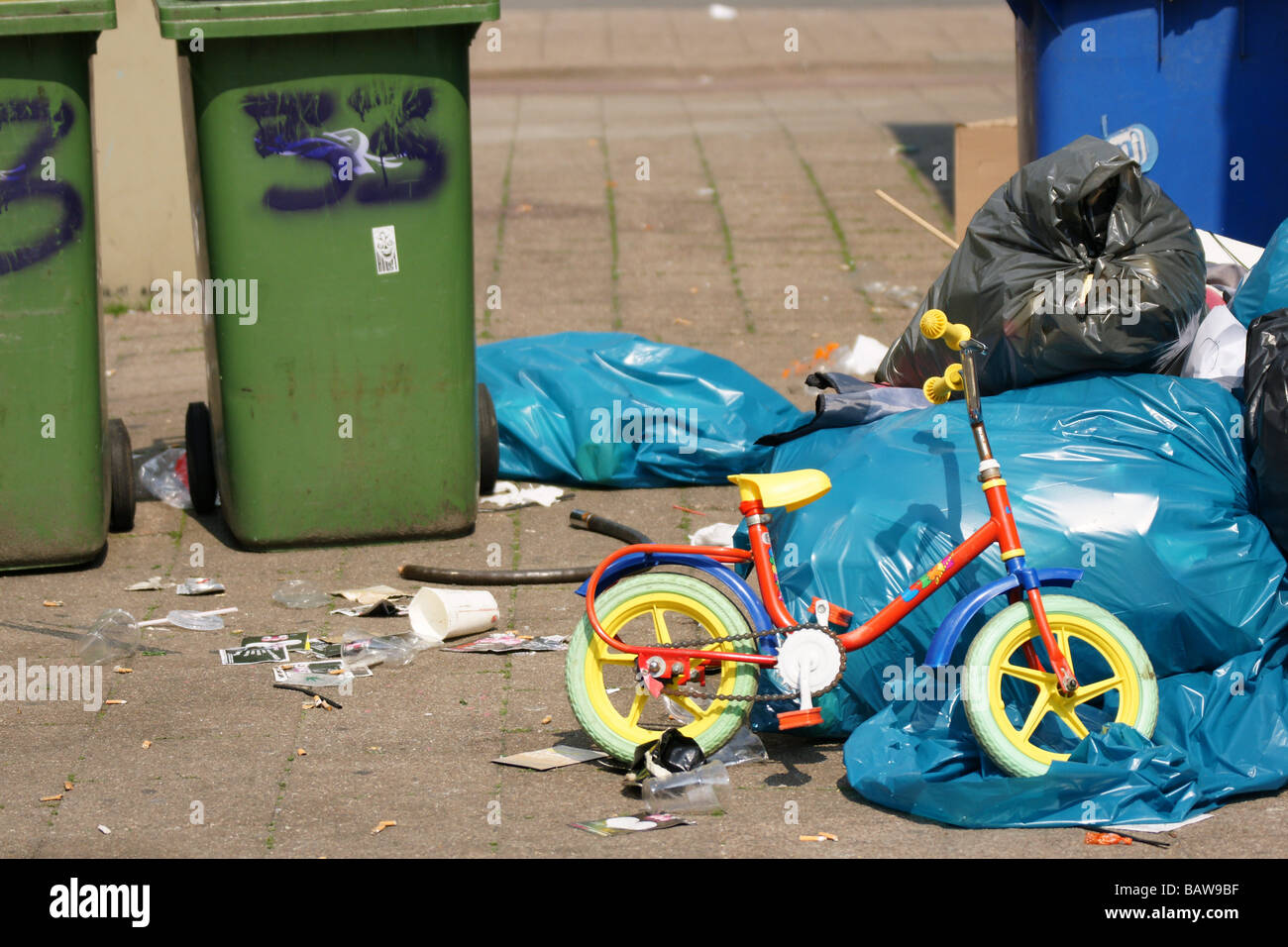 Broken toy plastic children's bicycle dumped garbage dust bin plastic