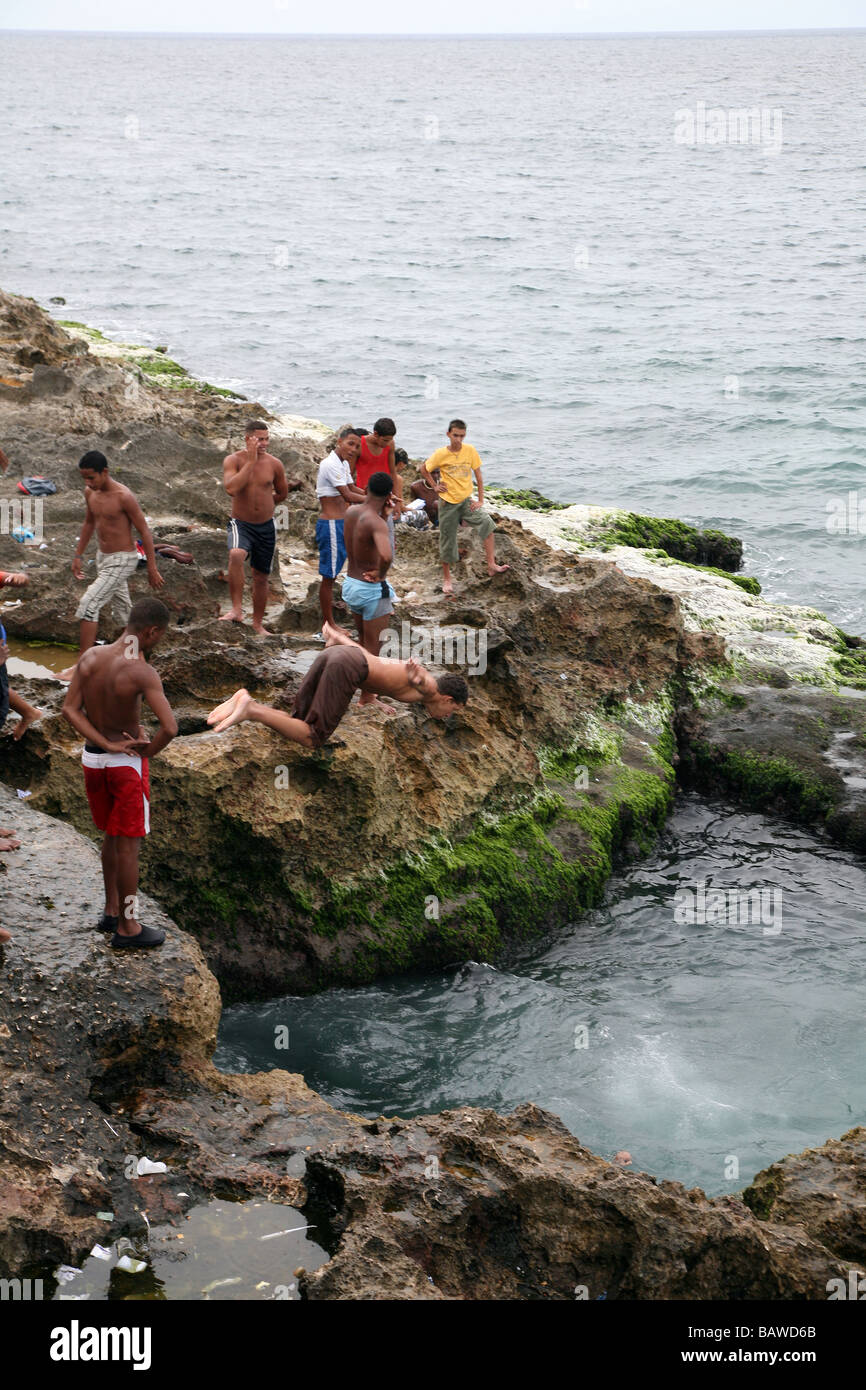 Malecón, boys jump in the water  of the rocks in Havana Cuba Stock Photo