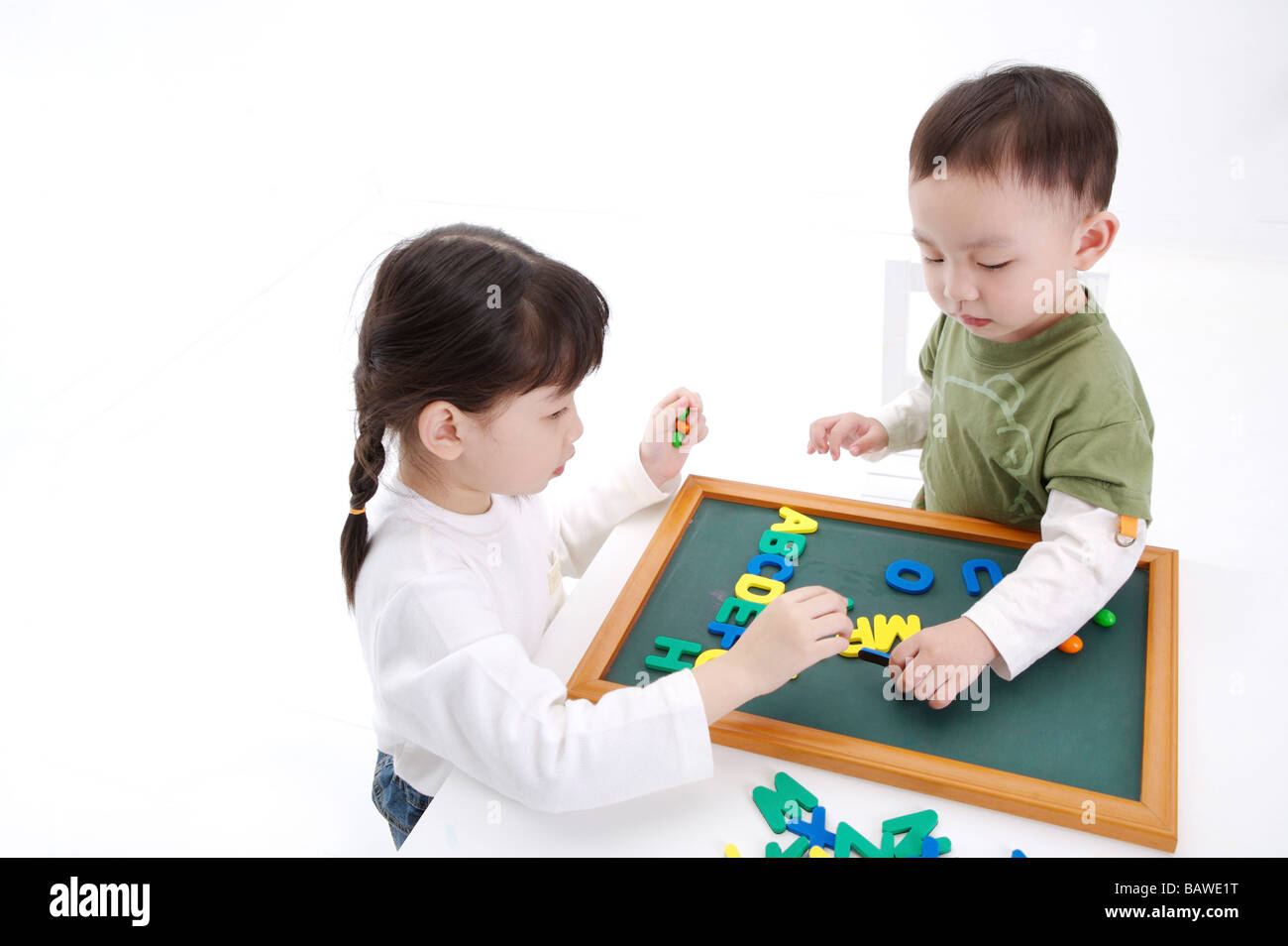 Children practicing spelling English vocabulary on chalkboard Stock Photo