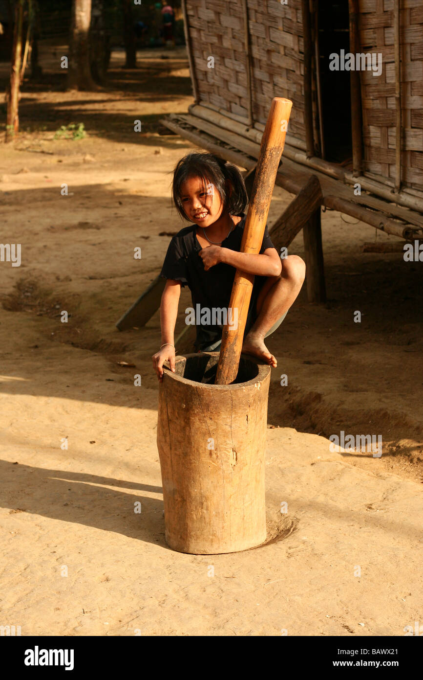 hill tribe girl grinding grain near Luang Prabang, Laos Stock Photo