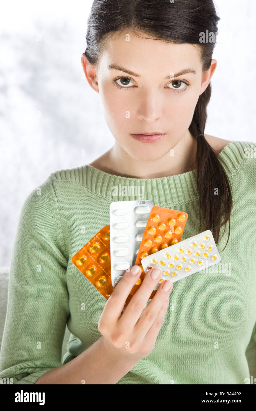 woman holding various blister packs of pills Stock Photo