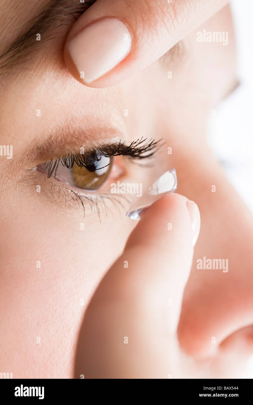 woman putting on eye lenses Stock Photo