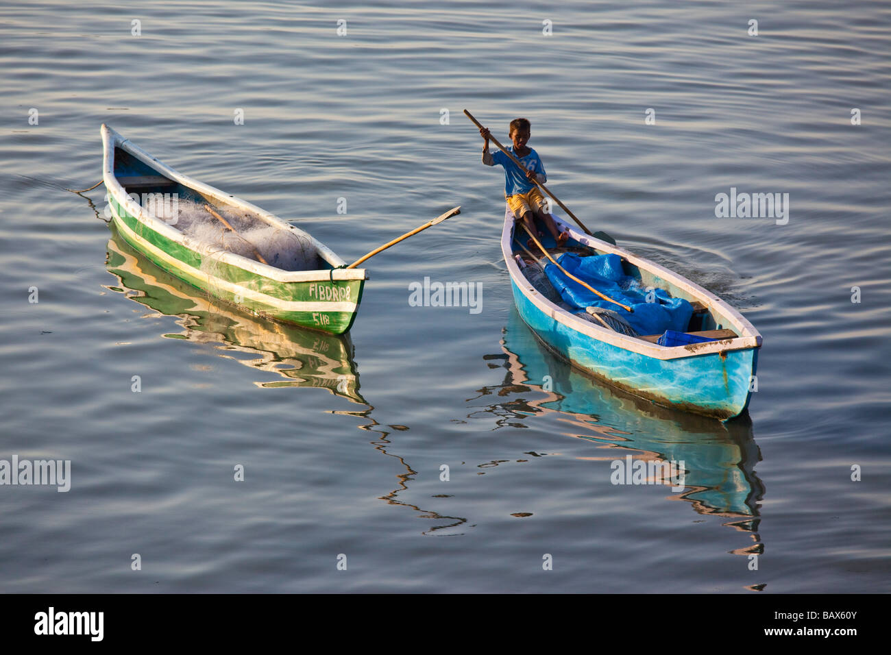 Boy in a Small Rowboat in Mumbai India Stock Photo