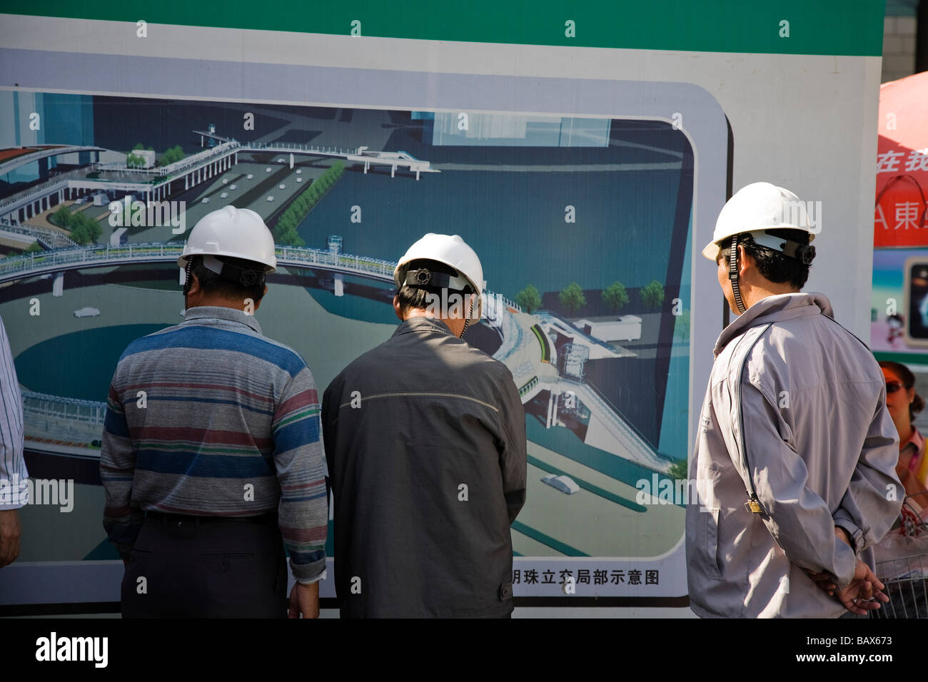 Construction engineers and surveyors in Shanghai China studying a plan. Stock Photo