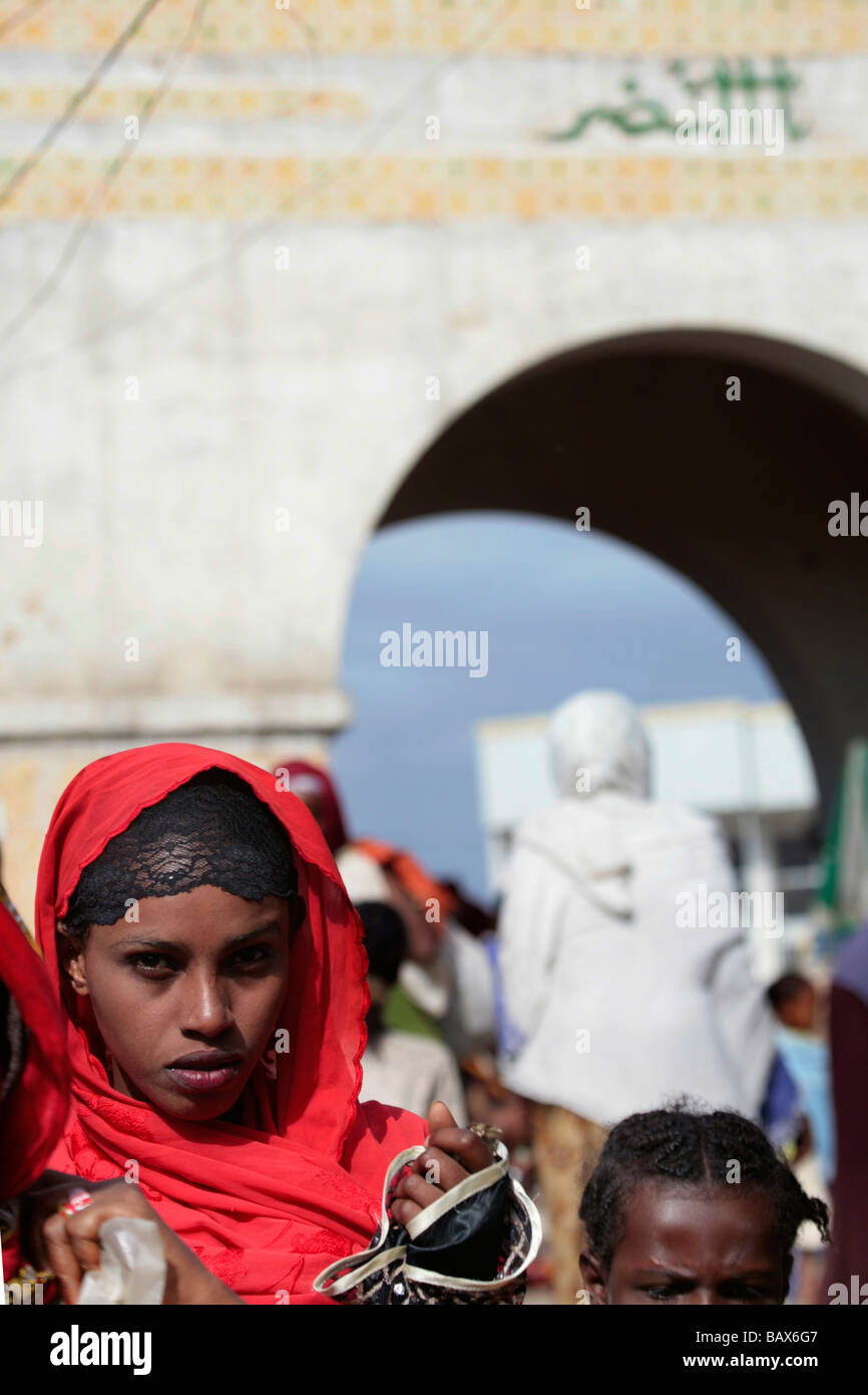 Pretty woman in a red headscarf in front of Harar Gate in the Christian Market of Old Harar Ethiopia Stock Photo