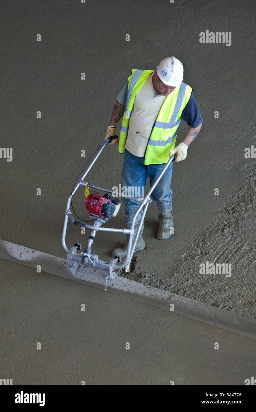 builder using machine to tamp concrete on construction site Stock Photo