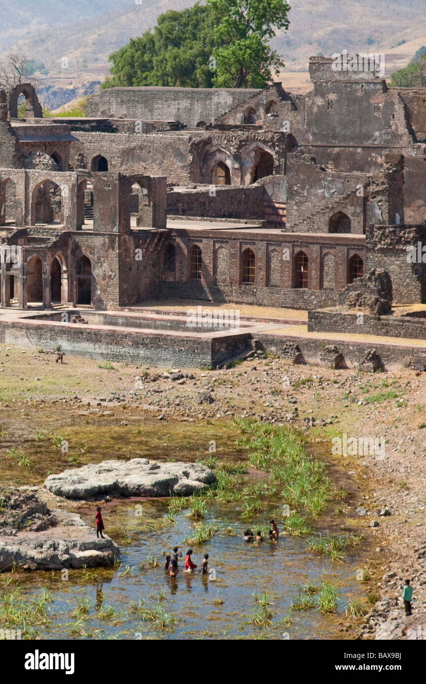 Children Play in Dry Lake and Ruins of Champa Baoli at Palace Enclosure in Mandu India Stock Photo