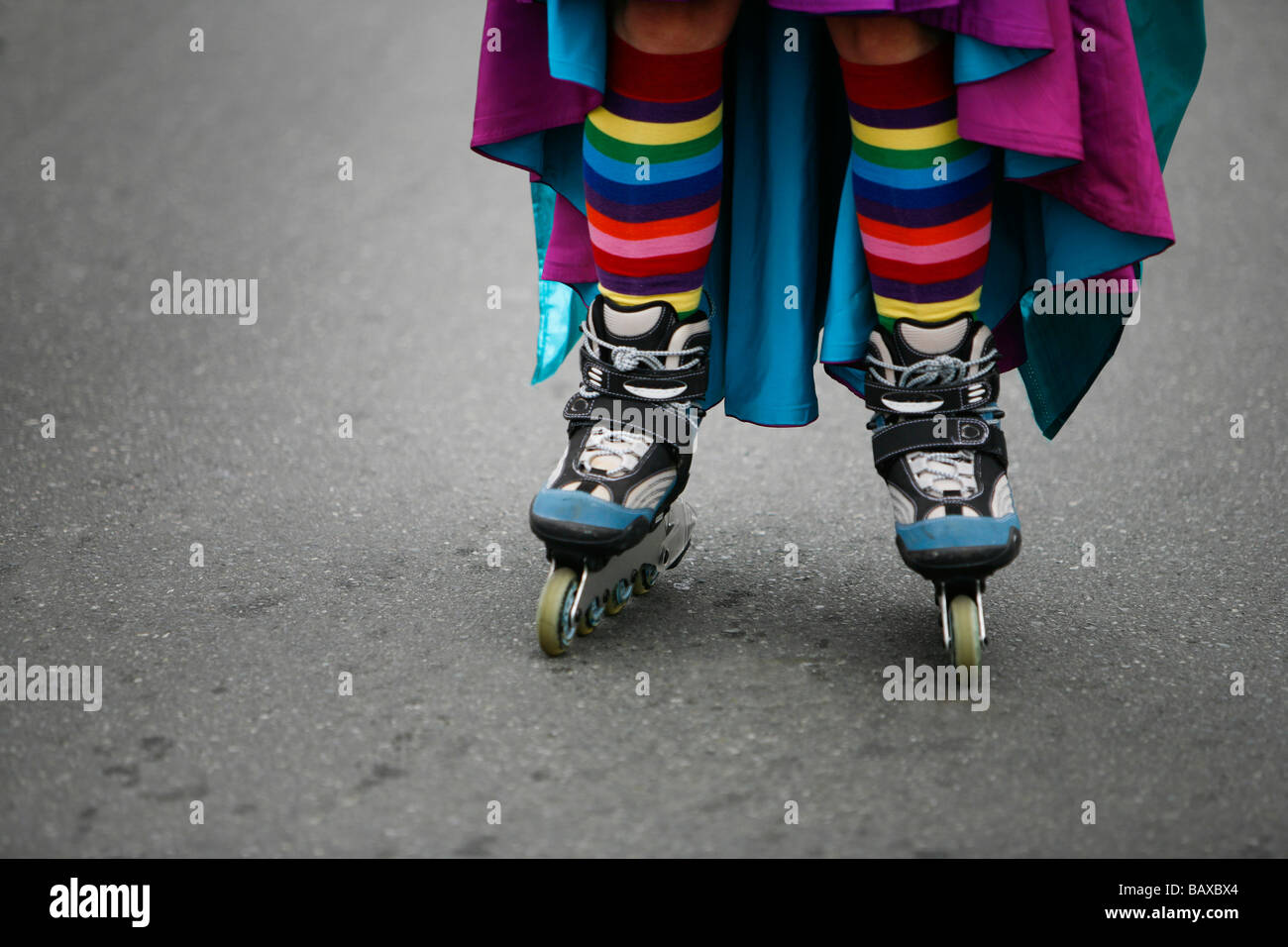 A women roller blades in rainbow colored stockings. Stock Photo