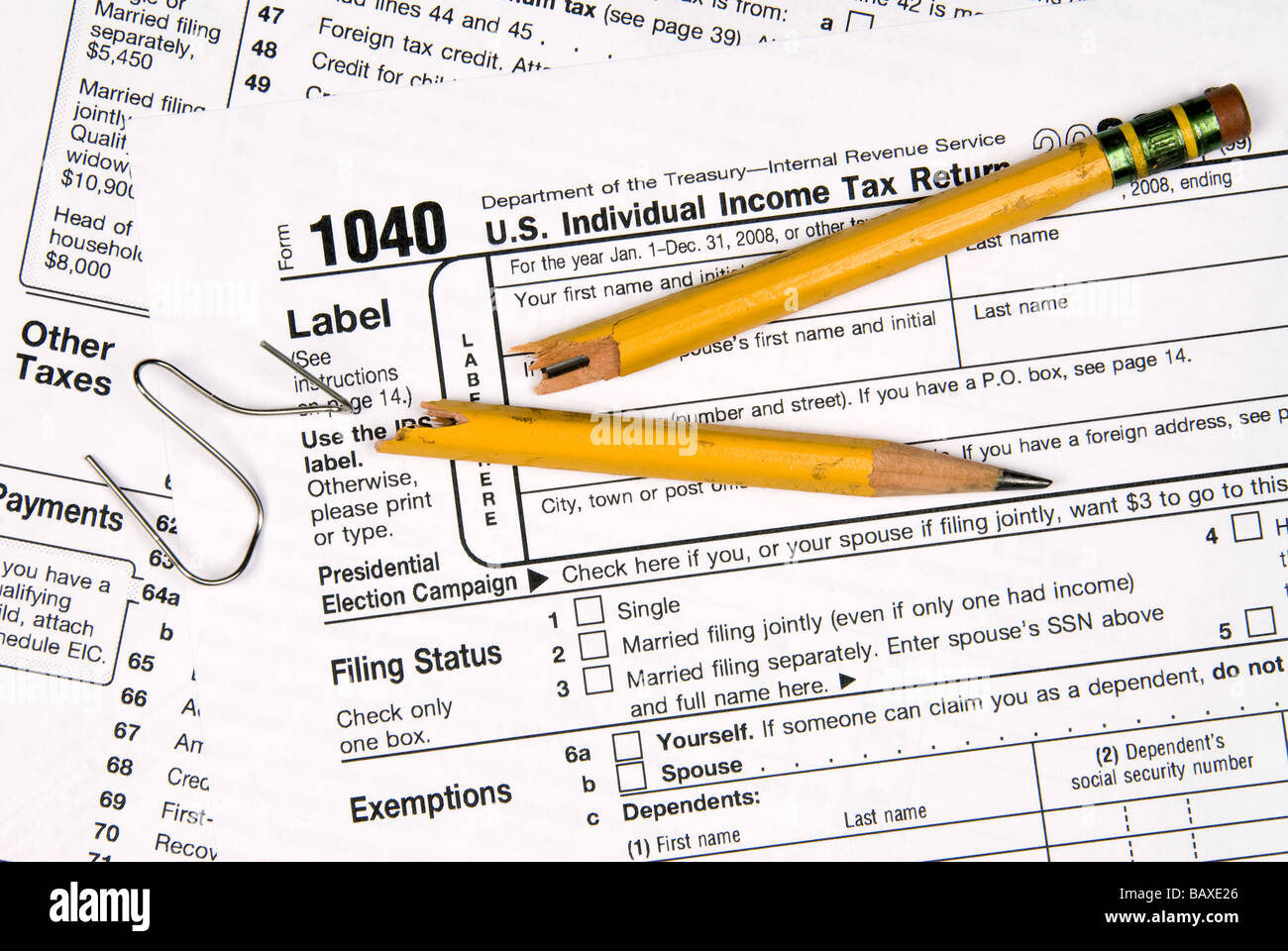 Tax forms a broken pencil and a twisted paper clip tell the story of a frustrated person Stock Photo