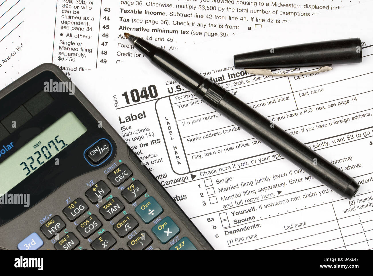 Tax forms a calculator and a pen showing the readiness to do ones taxes Stock Photo