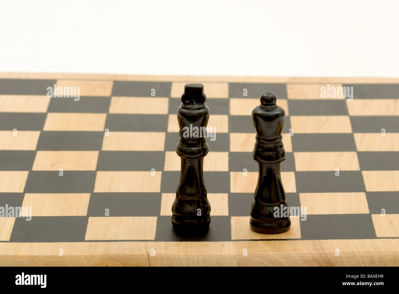 Two chess pieces, one king and one queen, on chess board Stock Photo