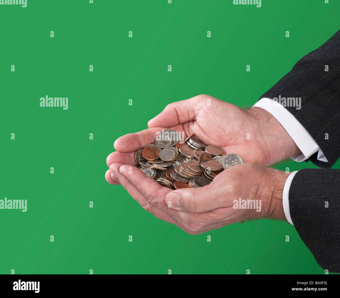 A man holds a pile of coins in his cupped hands Stock Photo