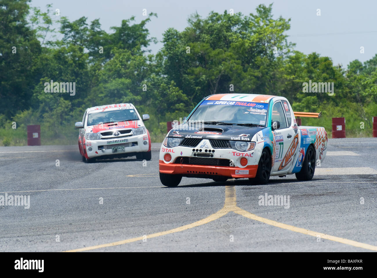 Mitsubishi and Toyota pickup trucks racing on a racetrack in Thailand Stock Photo
