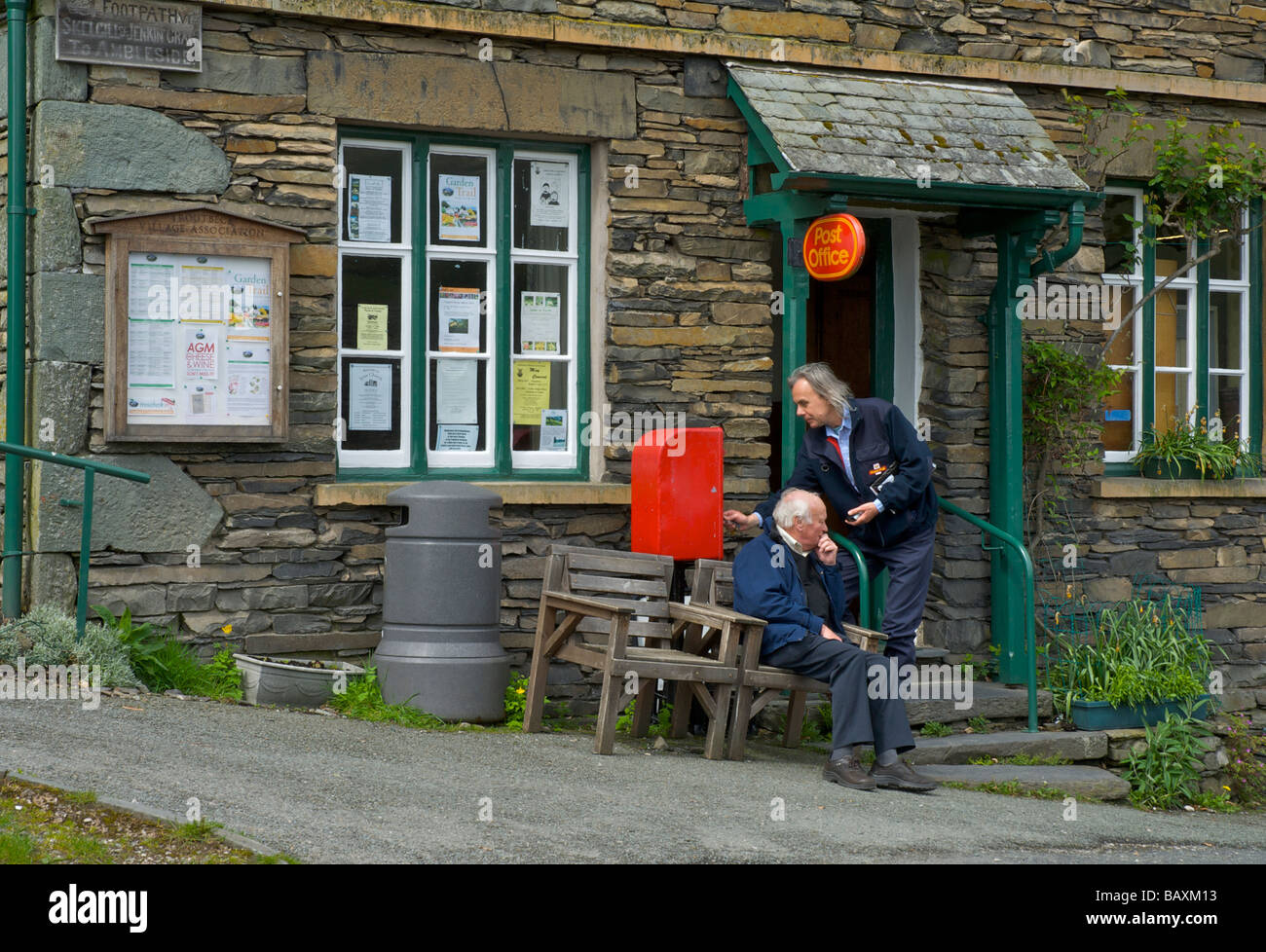 Postman emptying postbox at Troutbeck Post Office, Lake District National Park, Cumbria, England UK Stock Photo