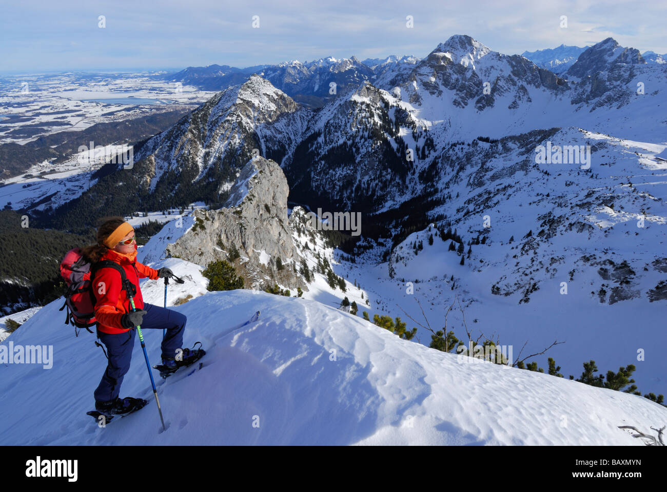 young woman ascending summit ridge of Sebenspitze, lake Forggensee, Schlicke and Gehrenspitze in background, Tannheim range, All Stock Photo