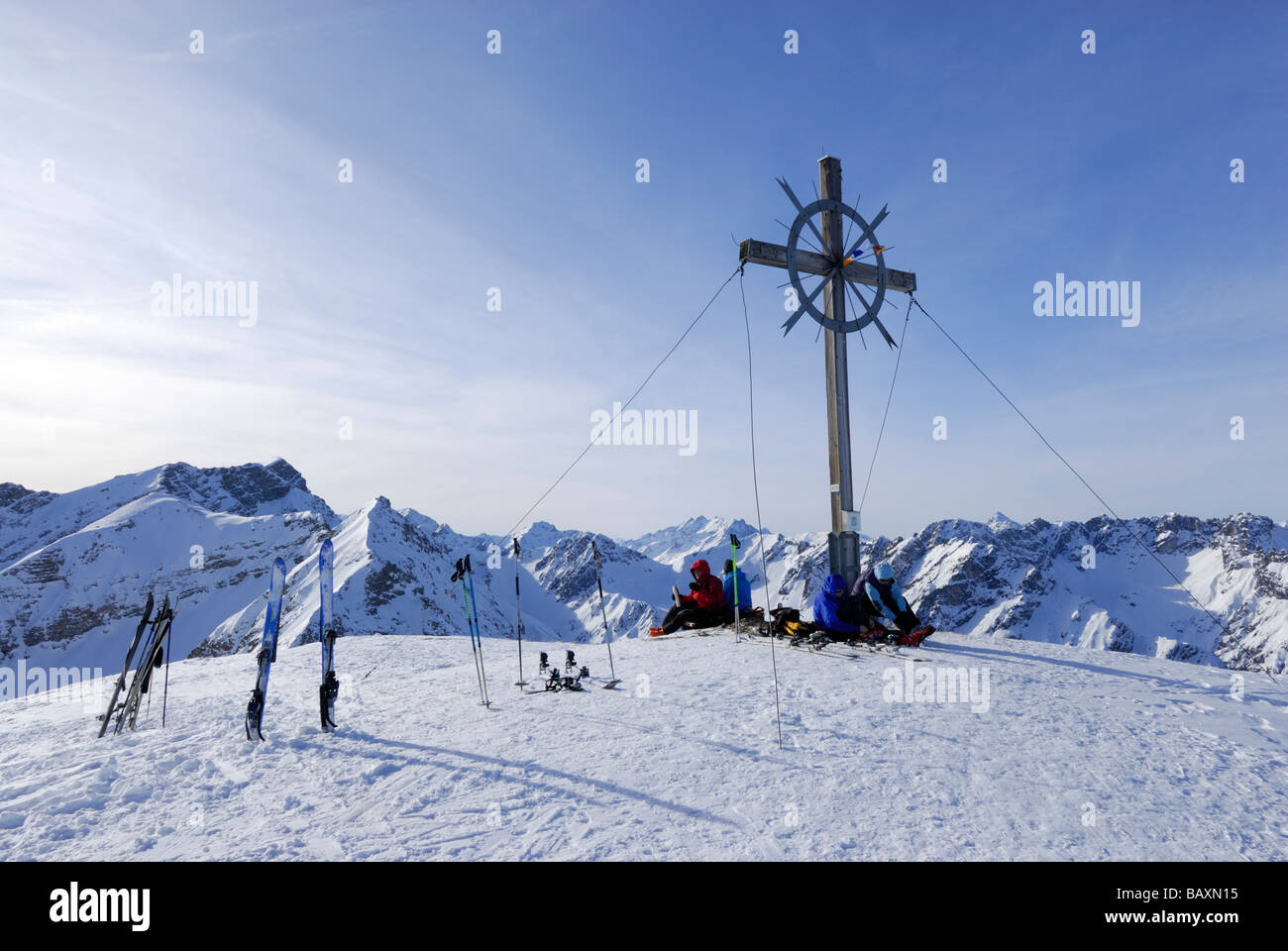 backcountry skiers at cross on summit of Galtjoch, Lechtal range, Tyrol, Austria Stock Photo