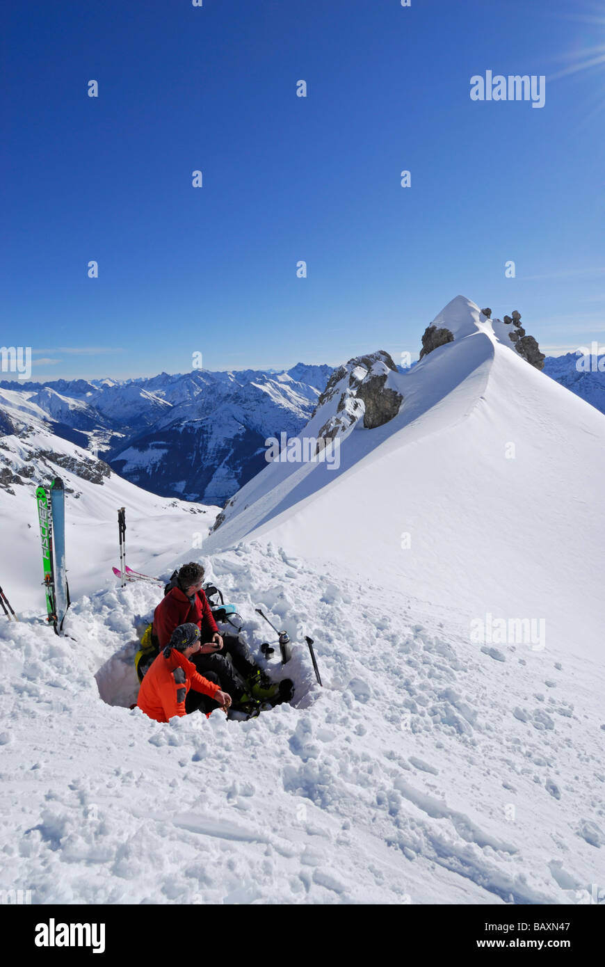 two backcountry skiers resting in snow pit, Woleggleskarspitze, Allgaeu range, Allgaeu, Tyrol, Austria Stock Photo